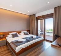 Novalja – luxusná vila s bazénom, jacuzzi a výhľadom na more - Luxusná spálňa vo vile s balkónom, podlaha s dreveným dekorom, veľké okná.