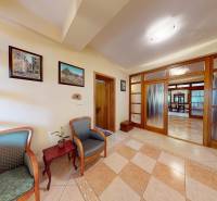 Veľkometrážny dom s wellness, bazénom a investičným potenciálom - Chodba v rodinnom dome s pohodlnými kreslami, stolíkom a dlaždicovou podlahou.