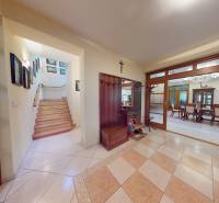 Veľkometrážny dom s wellness, bazénom a investičným potenciálom - V rodinnom dome je vstupná hala s dlažbou, schodiskom a jedálňou za presklenými dverami.