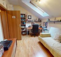 Veľkometrážny dom s wellness, bazénom a investičným potenciálom - Podkrovná izba v rodinnom dome s podlahou s dreveným dekorom, písacím stolom a sedačkou.