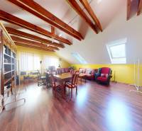 Veľkometrážny dom s wellness, bazénom a investičným potenciálom - Podkrovná izba v Rodinnom dome s podlahou s dreveným dekorom, sedacou súpravou a stolom.