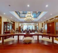 Veľkometrážny dom s wellness, bazénom a investičným potenciálom - Interiér rodinného domu so štýlovým nábytkom, lustrom a podlahou s dreveným dekorom.