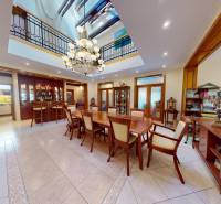 Veľkometrážny dom s wellness, bazénom a investičným potenciálom - Jedáleň v Rodinnom dome s veľkým dreveným stolom, lustrom a dekoráciami.