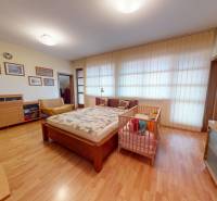 Veľkometrážny dom s wellness, bazénom a investičným potenciálom - Spálňa v rodinnom dome s dreveným dekorom podlahy, detská postieľka a dekorácie.