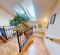 Veľkometrážny dom s wellness, bazénom a investičným potenciálom - Schodisko rodinného domu s podlahou s dreveným dekorom, obrazmi a dekoratívnym zábradlím.