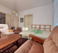 NA PREDAJ rodinný dom - Lehota nad Rimavicou - Interiér rodinného domu s pohodlnými kreslami, drevom obloženými stolmi a kachľovou pecou.