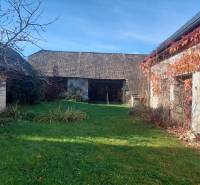 NA PREDAJ rodinný dom - Lehota nad Rimavicou - Záhrada s rodinným domom, stromy bez lístia a tráva obklopené múrmi.