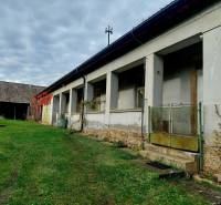 NA PREDAJ rodinný dom - Lehota nad Rimavicou - Rodinný dom s verandou a záhradou, obklopený zeleňou, pod zamračenou oblohou.