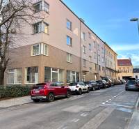 Na predaj parkovacie miesto, Beskydská, Bratislava, Staré Mesto - Ulica s autami, budovami, stromami, v pozadí modrá obloha a zaparkované garáže.