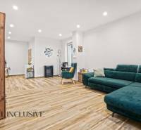 NA PREDAJ 4-IZBOVÝ RODINNÝ DOM V KOLÁROVE - Obývacia izba v rodinnom dome s podlahou v drevenom dekore a zeleným nábytkom.