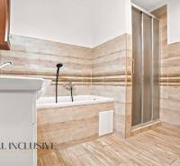 NA PREDAJ 4-IZBOVÝ RODINNÝ DOM V KOLÁROVE - Kúpeľňa s vaňou a sprchovacím kútom v rodinnom dome, podlaha s dreveným dekorom.