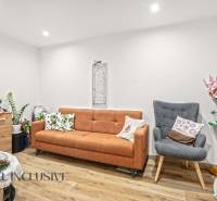 NA PREDAJ 4-IZBOVÝ RODINNÝ DOM V KOLÁROVE - Obývacia izba v rodinnom dome s pohovkou, kreslom a podlahou s dreveným dekorom.