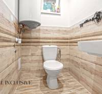 NA PREDAJ 4-IZBOVÝ RODINNÝ DOM V KOLÁROVE - Kúpeľňové zariadenie v rodinnom dome s toaletou a podlahou s dreveným dekorom.