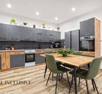 NA PREDAJ 4-IZBOVÝ RODINNÝ DOM V KOLÁROVE - Kuchyňa v rodinnom dome s podlahou s dreveným dekorom a moderným nábytkom.