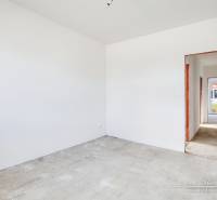 Novostavba 4-izbového rodinného domu v obci Slov.Nová Ves - Interiér rodinného domu s bielymi stenami a chodbou do ďalšej miestnosti.