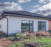 Novostavba 4-izbového rodinného domu v obci Slov.Nová Ves - Rodinný dom na predmestí Slovenskej Novej Vsi so záhradou a bielou fasádou.