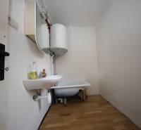 3-izb. byt v rekonštrukcii, Ľubochňa okres Ružomberok - Kúpeľňa v 3-izbovom byte s umývadlom, vaňou, bojlerom a podlahou s dreveným dekorom.