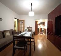 MAXFIN REAL - predaj dvojgarsónky - Nitra, Klokočina - Dvojgarsónka s podlahou s dreveným dekorom, jedálenským stolom a kuchyňou v pozadí.