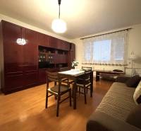 MAXFIN REAL - predaj dvojgarsónky - Nitra, Klokočina - Obývacia časť dvojgarsónky s podlahou s dreveným dekorom, nábytkom a jedálenským stolom.