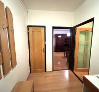 MAXFIN REAL - predaj dvojgarsónky - Nitra, Klokočina - Dvojgarsónka s podlahou s dreveným dekorom, vešiakovou stenou a otvorenými dverami do miestnosti.