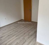 Na prenajom najlacnejšie komerčne priestory v Prievidzi. - Obchodné priestory s podlahou s dreveným dekorom a bielymi stenami a dverami.