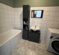 2iz byt v novostavbe Hlohovec Zľava!!! - Kúpeľňa v 2-izbovom byte s vaňou, umývadlom a práčkou, obklopená bielymi kachličkami.