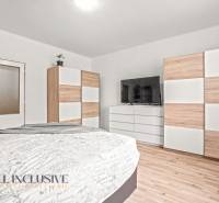 NA PREDAJ 6-IZBOVÝ RD S VEĽKÝM POZOMKOM, DOLNÝ ŠTÁL - Spálňa v rodinnom dome s televíziou, skrinkami a podlahou s dreveným dekorom.