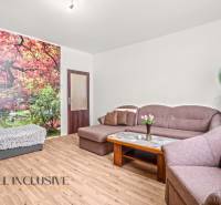 NA PREDAJ 6-IZBOVÝ RD S VEĽKÝM POZOMKOM, DOLNÝ ŠTÁL - Obývacia izba s pohovkou, fototapetou stromov a podlahou s dreveným dekorom v rodinnom dome.