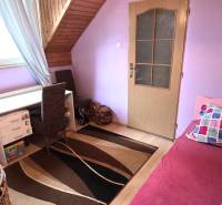 Na predaj 2 rodinné domy vhodné na bývanie i podnikanie, Trnava! - Detská izba v podkroví rodinného domu so stolom, posteľou a kobercom.
