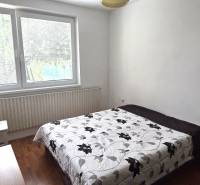 Na predaj 2 rodinné domy vhodné na bývanie i podnikanie, Trnava! - Spálňa s posteľou a kvetinovou prikrývkou, podlaha s dreveným dekorom, veľké okno.