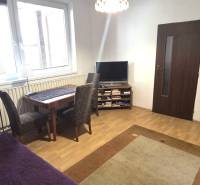 Na predaj 2 rodinné domy vhodné na bývanie i podnikanie, Trnava! - Obývacia izba v rodinnom dome s podlahou s dreveným dekorom, televízorom a jedálenským stolom.