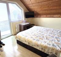 Na predaj 2 rodinné domy vhodné na bývanie i podnikanie, Trnava! - Spálňa v rodinnom dome s cvičebným bicyklom a podlahou s dreveným dekorom.