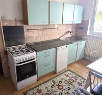 Na predaj 2 rodinné domy vhodné na bývanie i podnikanie, Trnava! - Kuchyňa s plynovým sporákom, zelenými skrinkami a stolom v rodinnom dome.