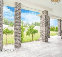 NA PREDAJ NADŠTANDARDNÁ 4-IZB. NOVOSTAVBA, DUN. KLÁTOV - Terasa rodinného domu v Dunajskom Klátove s tehlovými stĺpmi a záhradným nábytkom.