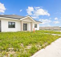 NA PREDAJ 4-IZBOVÁ NOVOSTAVBA, POVODA - Rodinný dom na ulici Povoda v Dunajskej Strede obklopený zelenou lúkou a plotom.