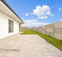 NA PREDAJ 4-IZBOVÁ NOVOSTAVBA, POVODA - Dvor rodinného domu na ulici Povoda v Dunajskej Strede s vydláždenou terasou a plotom.