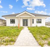 NA PREDAJ 4-IZBOVÁ NOVOSTAVBA, POVODA - Rodinný dom na ulici Povoda v Dunajskej Strede s trávnikom a dlaždicovým chodníkom.