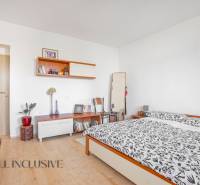 NA PREDAJ 5-IZBOVÝ POSCH. RODINNÝ DOM, DUNAJSKÁ STREDA - Spálňa v rodinnom dome s manželskou posteľou, policami a kreslom, svetlé steny.