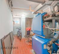 NA PREDAJ 5-IZBOVÝ POSCH. RODINNÝ DOM, DUNAJSKÁ STREDA - Kotolňa s modrobielym kotlom, bicyklom a červenohnedou podlahou v rodinnom dome.