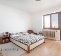 NA PREDAJ 5-IZBOVÝ POSCH. RODINNÝ DOM, DUNAJSKÁ STREDA - Svetlá spálňa s veľkým oknom, posteľou a kreslom v rodinnom dome.