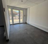 Prenájom obchod/kancelária NP nová kompletná rekonštrukcia, centrum PB - Priestranné obchodné priestory s veľkými oknami a výhľadom na vonkajšiu časť.