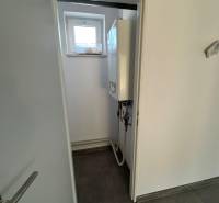 Prenájom obchod/kancelária NP nová kompletná rekonštrukcia, centrum PB - Interiér obchodných priestorov s moderným kotlom a malým oknom v stene.