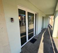 Prenájom obchod/kancelária NP nová kompletná rekonštrukcia, centrum PB - Obchodné priestory na Moyzesovej ulici v Považskej Bystrici s bielymi dverami a sklenenými oknami.