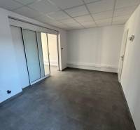Prenájom obchod/kancelária NP nová kompletná rekonštrukcia, centrum PB - Obchodné priestory s posuvnými dverami a dlažbou. Neutrálna a svetlá miestnosť.