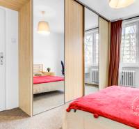 Zariadený 2-izbový byt, DVE NEPRIECHODNÉ IZBY, OC RETRO - Spálňa v 2-izbovom byte so vstavanou skriňou, koberec a dekoračné prvky.