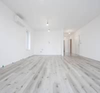 2 izb.BYT s POZEMKOM, PARKINGOM, Golf rezort Hrubá Borša - Svetlá izba v 2-izbovom byte s podlahou s dreveným dekorom a bielymi stenami.