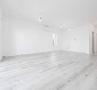 2 izb.BYT s POZEMKOM, PARKINGOM, Golf rezort Hrubá Borša - Priestranná izba s podlahou s dreveným dekorom v 2-izbovom byte.