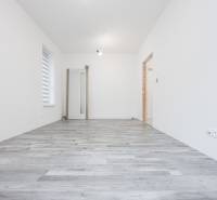 2 izb.BYT s POZEMKOM, PARKINGOM, Golf rezort Hrubá Borša - Interiér 2-izbového bytu s bielymi stenami a podlahou s dreveným dekorom.