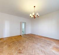 Na predaj 2,5 izbový byt v pôvodnom stave, 79 m2, Pod Sokolice, TN - Svetlá izba s podlahou s dreveným dekorom, luster visí v 2-izbovom byte.