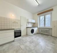 Na predaj 2,5 izbový byt v pôvodnom stave, 79 m2, Pod Sokolice, TN - Kuchyňa v 2-izbovom byte s bielymi dlaždicami, sporákom a práčkou.